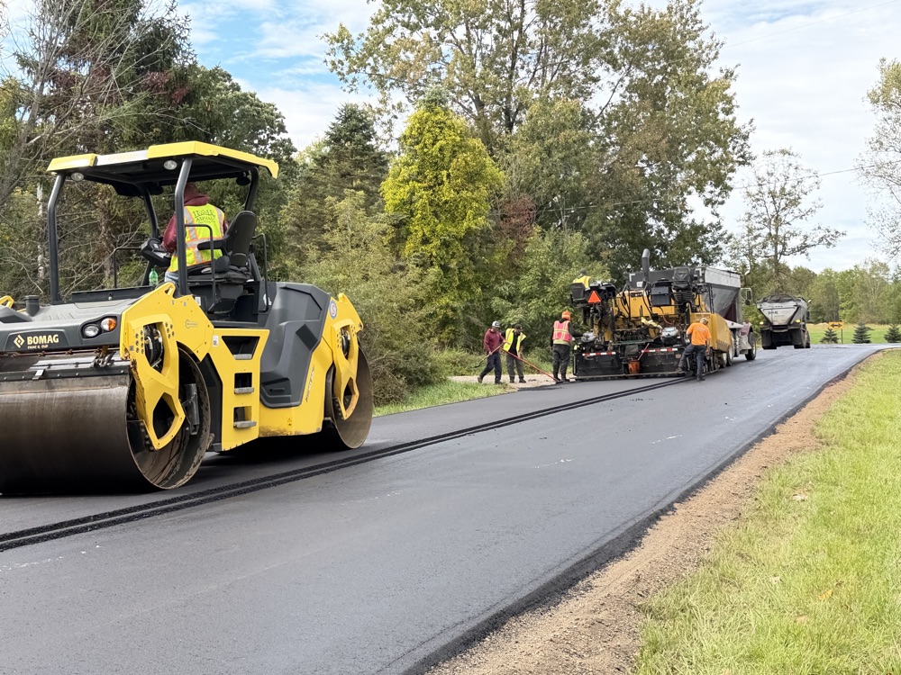 Bomag roller and asphalt paver on a fresh road